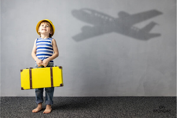Lapsi matkalla ja keltainen matkalaukku